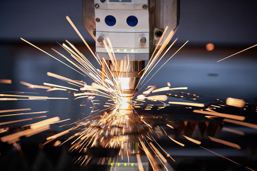 Laser cutting. Metal machining with sparks on CNC laser engravin